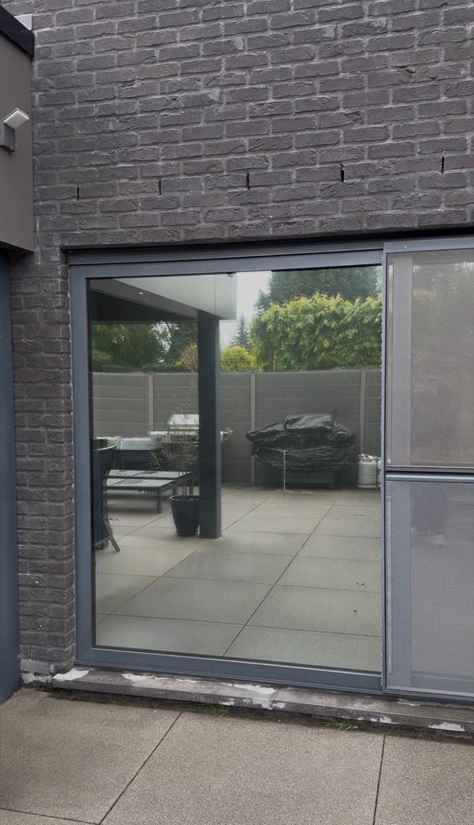 Porte-fenêtre avec film effet miroir posé, reflétant la terrasse extérieure